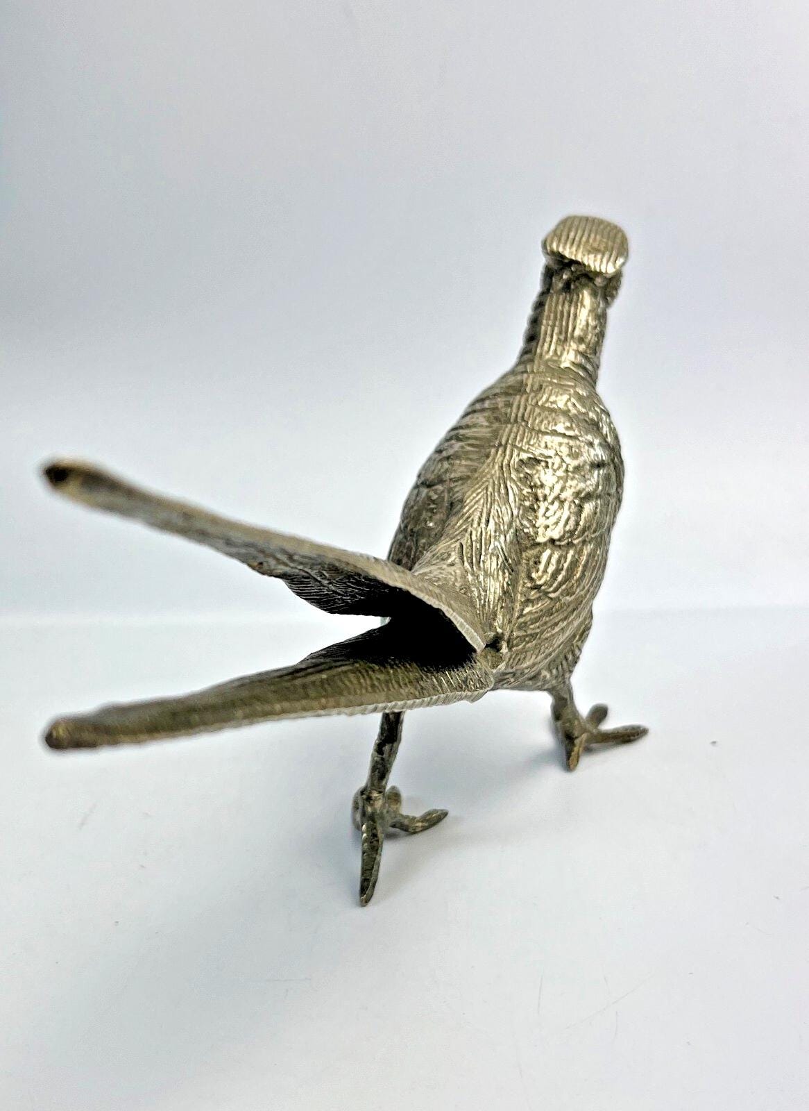 Antique pheasant cock bird in a heavy metal. bird sculpture pheasant sculpture