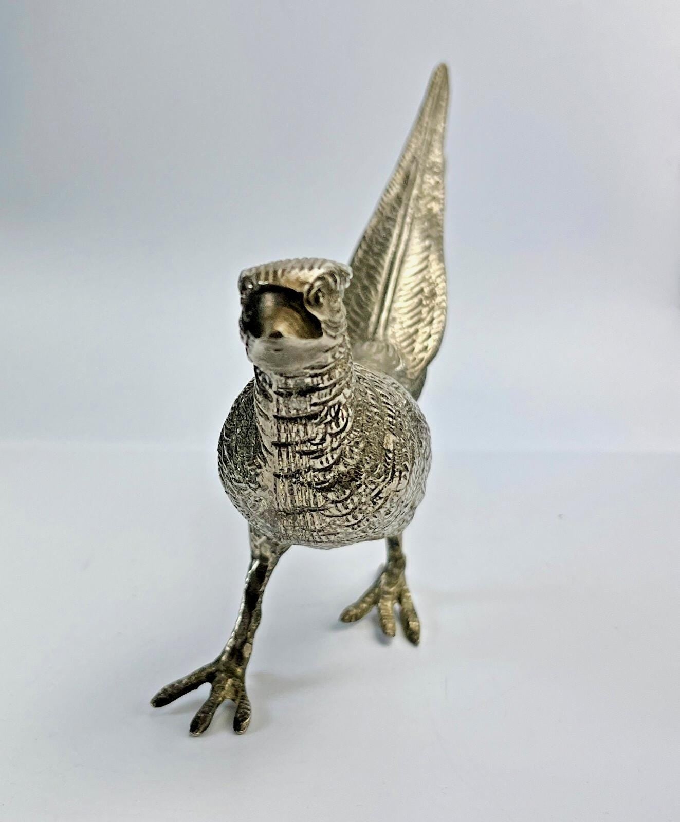 Antique pheasant cock bird in a heavy metal. bird sculpture pheasant sculpture