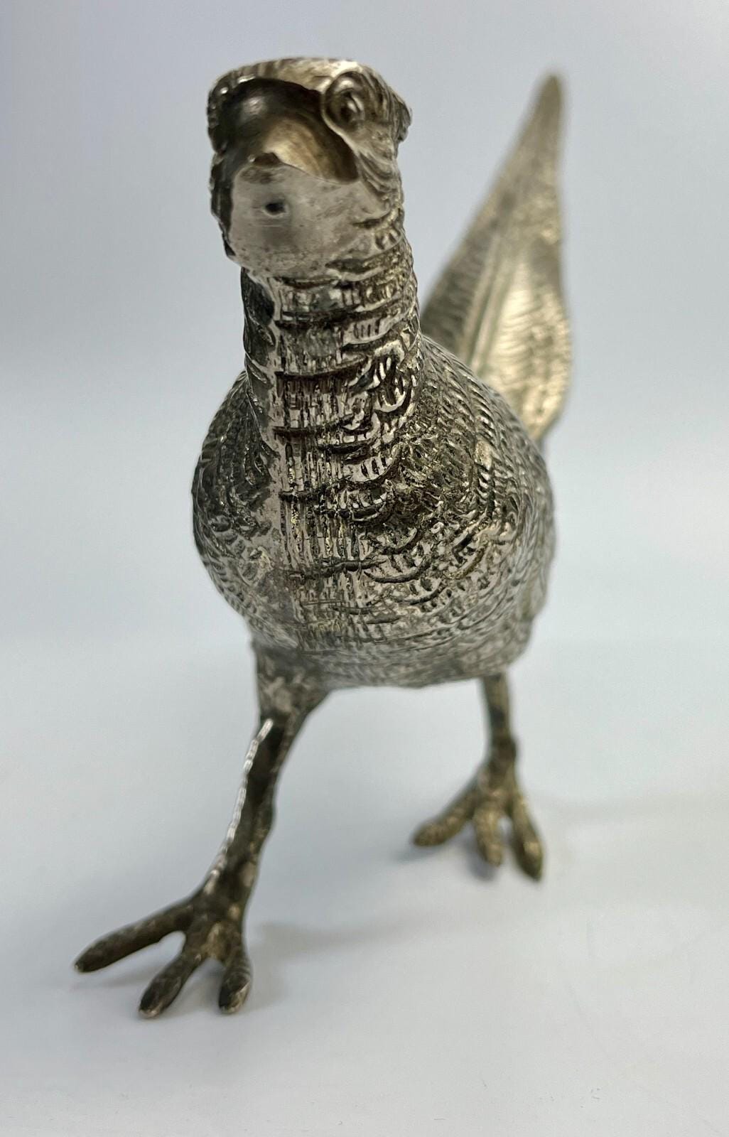 Antique pheasant cock bird in a heavy metal. bird sculpture pheasant sculpture