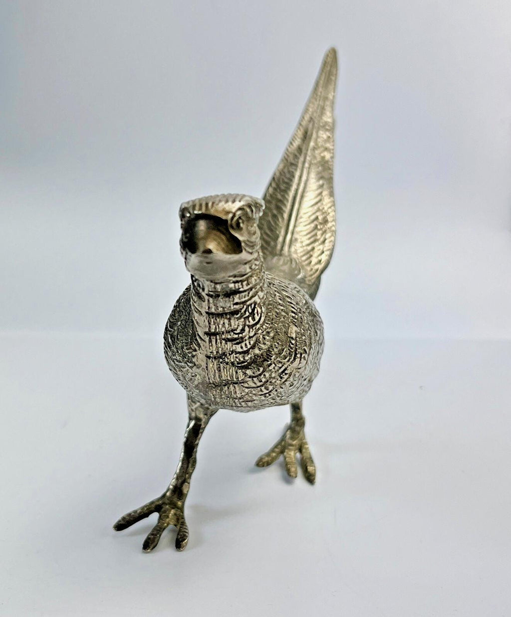 Antique pheasant cock bird in a heavy metal. bird sculpture pheasant sculpture